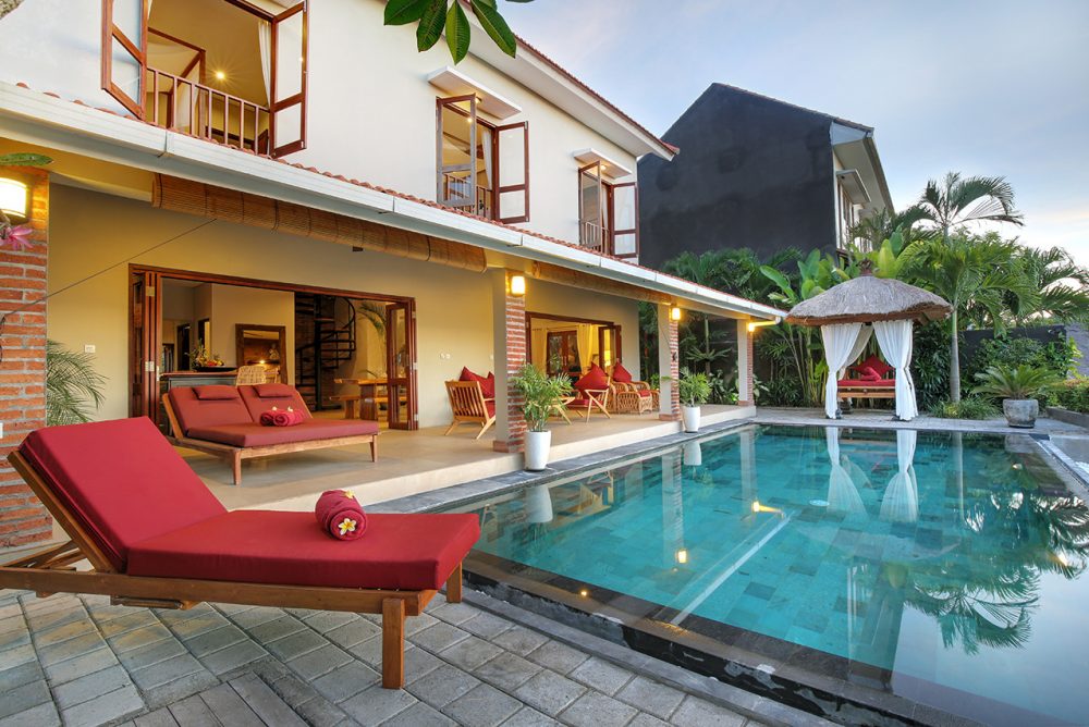 The villa pool  with red sundeck and small gazebo